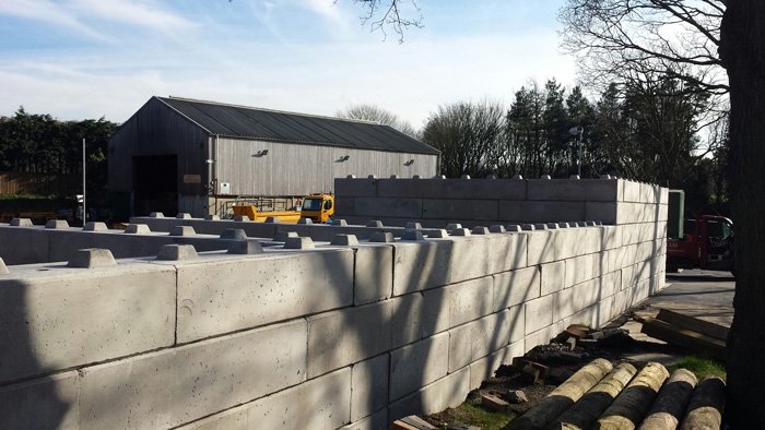 Duo block walling running along a yard in front of a farm building