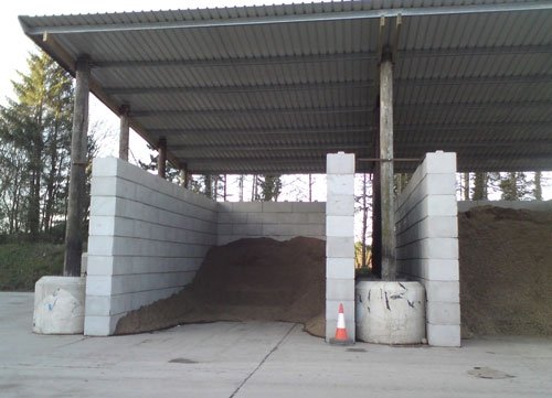 Duo block walls forming a covered bay filled with stored soil