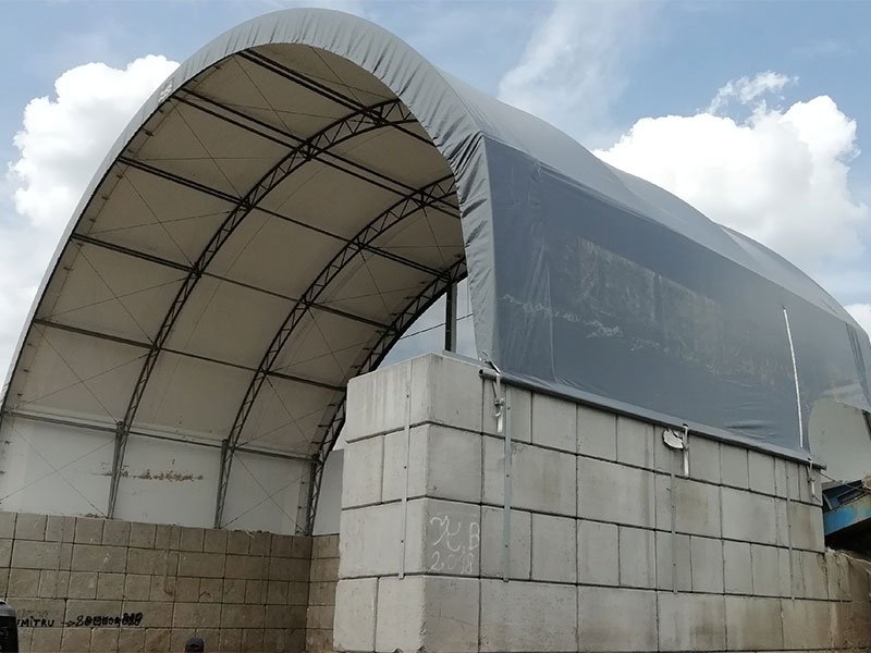 Fabric arched shelter mounted on Legato block walls at a depot