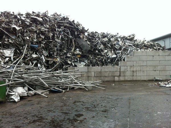 Shredded scrap metal heaped against a Duo block retaining wall