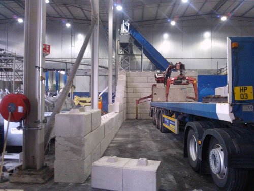 Lorry-mounted crane placing Duo blocks to build a wall inside a plant building