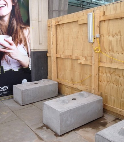 Kentledge blocks weighting the base of a timber site hoarding
