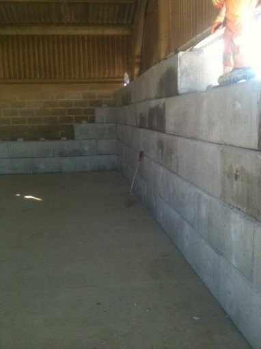 Duo block wall forming an internal storage bay inside a building