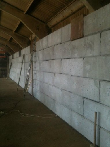 Long Duo block wall lining the inside of a timber framed barn