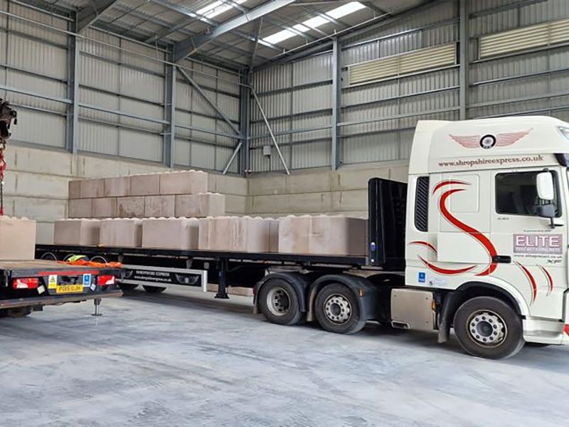 Articulated lorry loaded with concrete blocks inside a covered loading bay