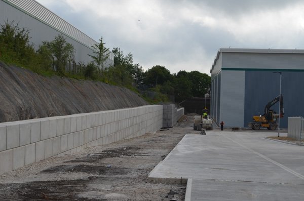 Legato block retaining wall holding an embankment beside a new industrial unit