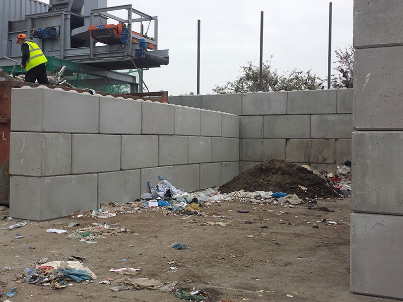 Legato interlocking block walls forming storage bays at a waste recycling yard