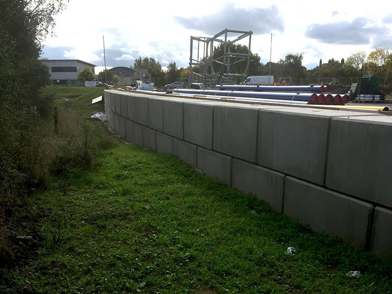 Two block high Legato retaining wall edging a level site above a grass bank