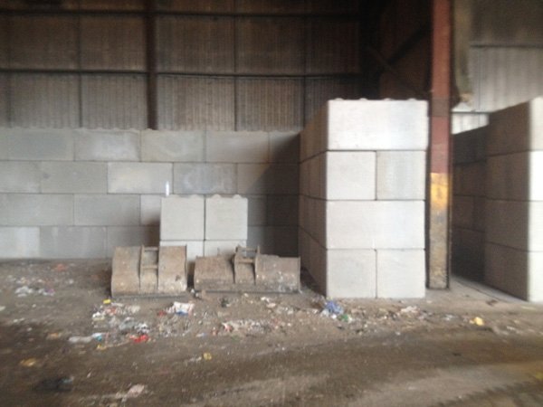 Legato interlocking block wall forming a storage bay inside an industrial shed