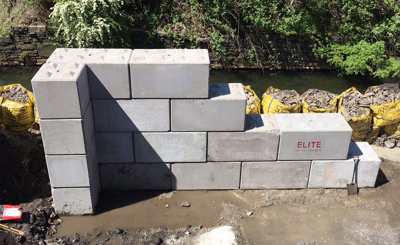 Legato blocks stepped into a retaining structure beside a watercourse
