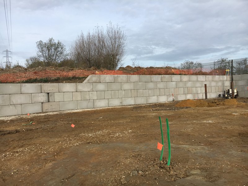Low Legato block wall retaining earth along the edge of a cleared site