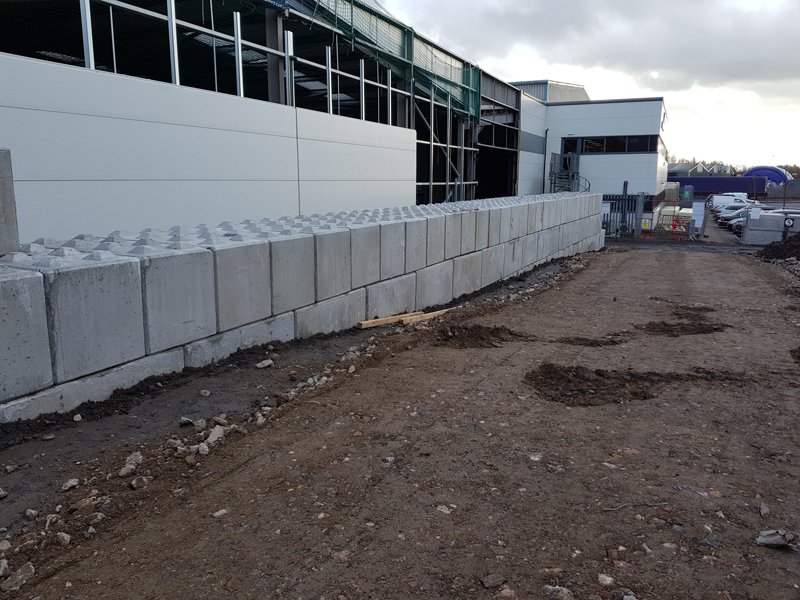 Legato interlocking blocks forming a boundary wall beside a new commercial unit