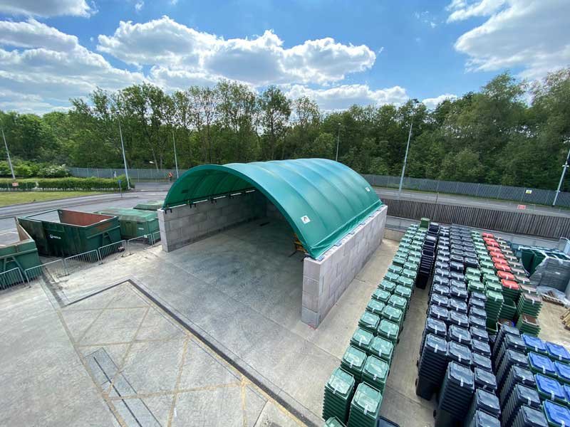 Legato block bay with a curved green canopy beside stacks of waste bins
