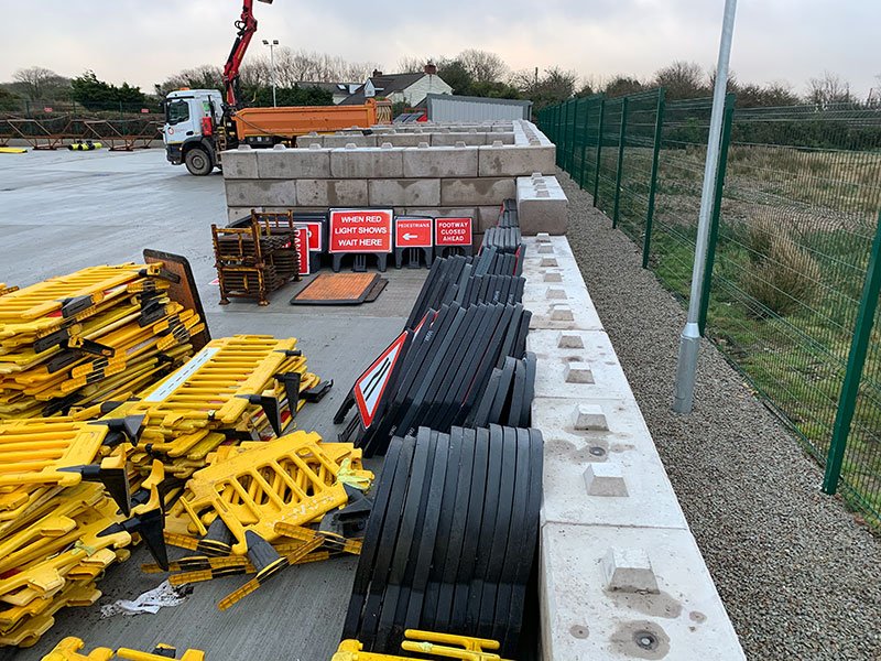 Traffic management barriers and ducting stored behind a precast block bay wall