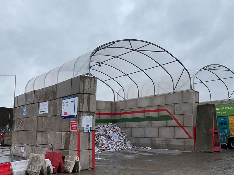 Legato block wall carrying a fabric canopy over a waste storage bay