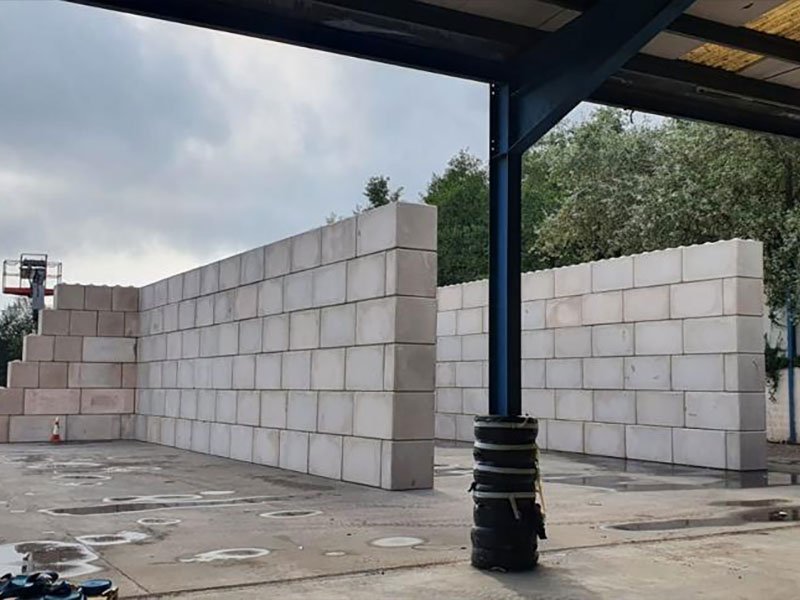 Legato interlocking blocks forming a storage bay wall beneath a yard canopy