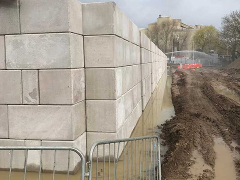 Legato blocks forming a tall external corner wall beside a muddy site road