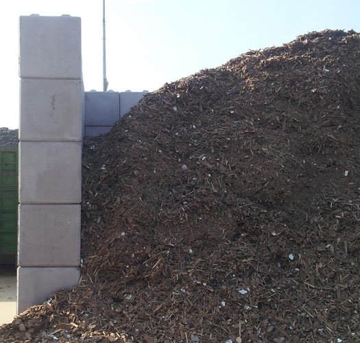 Legato block wall retaining a large woodchip stockpile