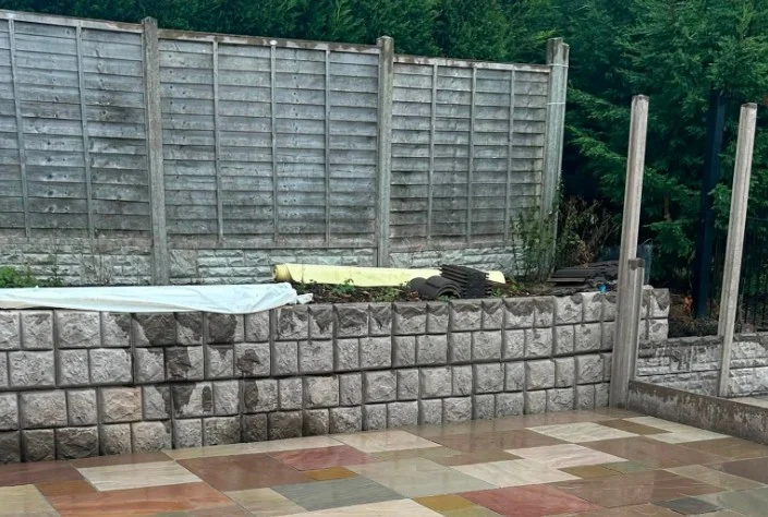 Cobblestone-finish Retainer-Rock gravel boards forming a low wall beneath a timber fence
