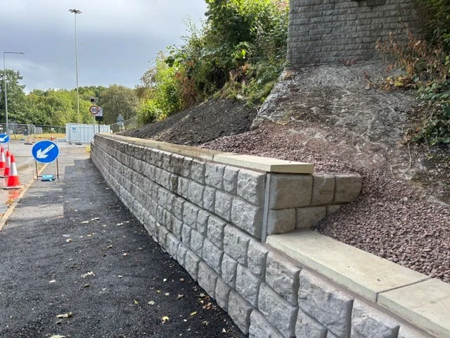 Retainer-Rock walling retaining an excavated bank beside a new roadside footway
