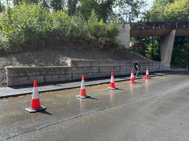 Retainer-Rock retaining wall supporting an embankment beside a new road under a bridge